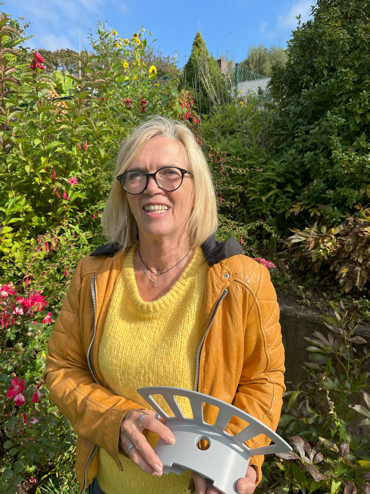 Zufriedene Gartenbesitzerin zeigt den Gardenicer Classic – die einfache Lösung für Schlauchordnung ohne Werkzeug